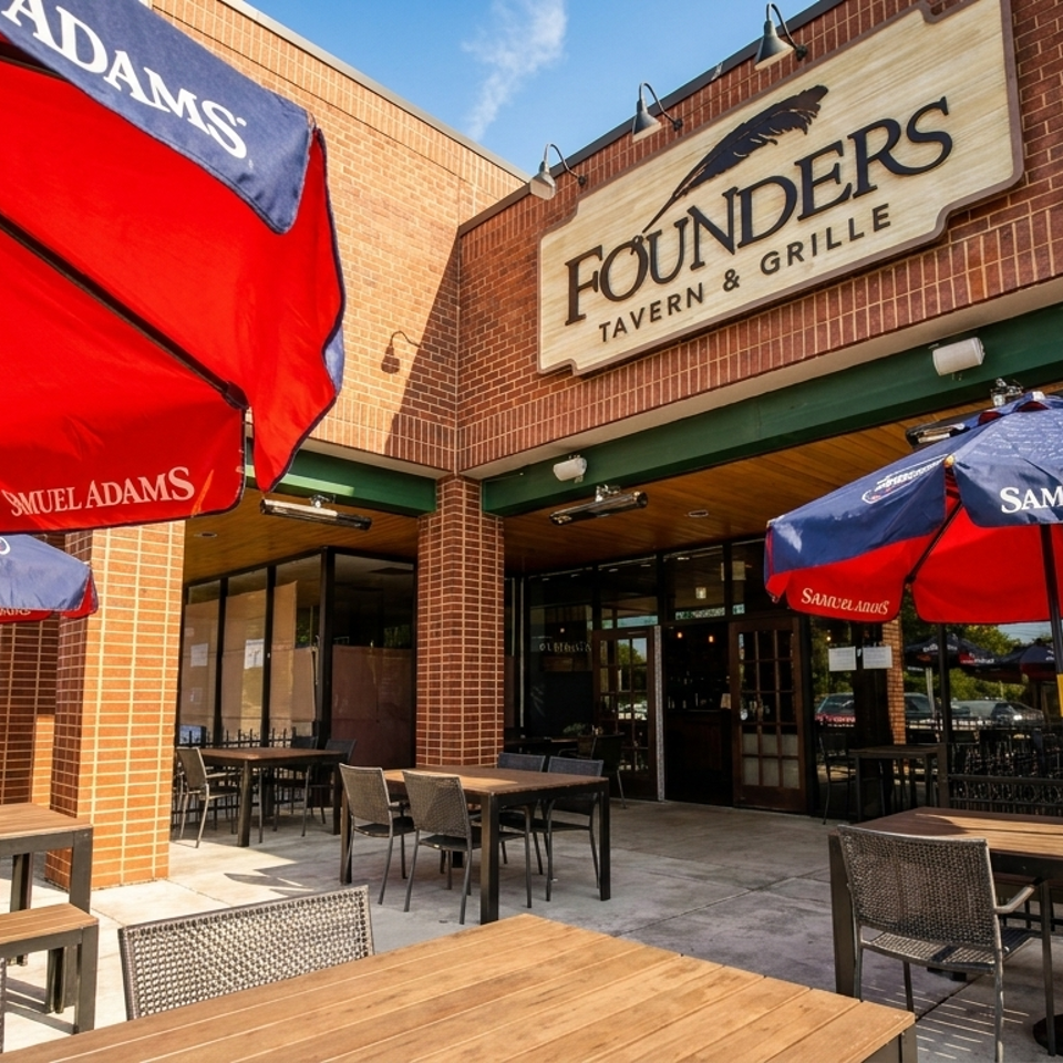 Founders Tavern & Grille exterior with outdoor patio seating under red and blue Samuel Adams umbrellas.